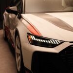 Une voiture blanche est exposée dans une salle d'exposition