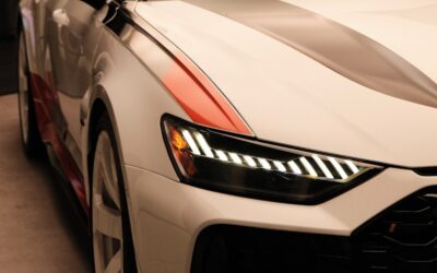 Une voiture blanche est exposée dans une salle d'exposition